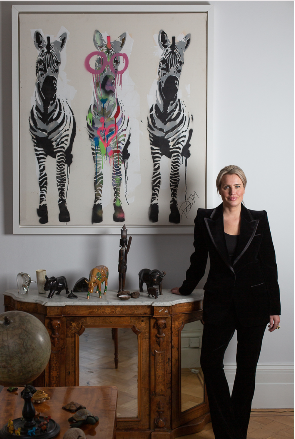 Gabrielle du Plooy, owner & director of Zebra One Gallery, photographed in front of a zebra triptych — Hampstead, London